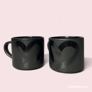 Матова чашка з глянцевим серцем — мінімалізм і стиль у кожному ковтку Дві чорні чашки з глянцевим принтом у формі серця на матовому фоні