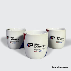 Горнята з логотипом Pan America — лаконічне брендування для автокомпанії Три білі чашки з логотипом Pan America та червоно-синім графічним елементом